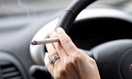Woman smoking a cigarette in car