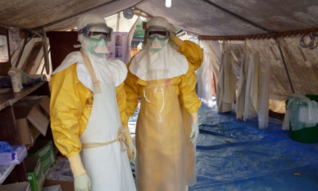 Medical staff of Medecins Sans Frontieres (Doctors Without Borders) put on their protective suits as they stand in a tent of the MSF Donka treatment centre in Conakry.