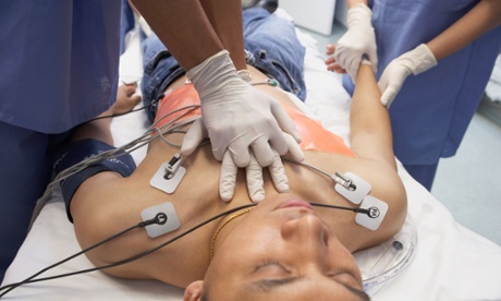 Doctor performing CPR on Asian patient in the emergency room
