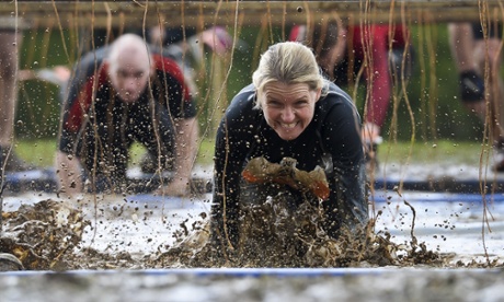 Racers go through the electric pool on their bellies to avoid being electrocuted by 80,000 volts in freezing water as  they take part in the Tough Mudder race in Oxfordshire, 