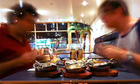 two men eating curry in indian restaurant