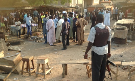 People gather at the scene of a bomb blast at a fruit and vegetable market in the Jimeta area of Yola, Adamawa, Nigeria November 18, 2015.