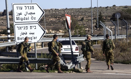 Israeli soldiers patrol the roundabout at the Gush Etzion junction situated on the main road south to Hebron.