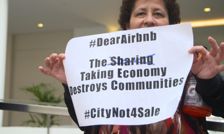 Campaigner and Causa Justa member Bilda Linares holds a banner at the protest inside Airbnb's head office