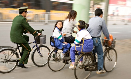Parents ride their bicycles in China with children