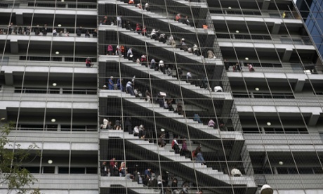 Workers stand at the emergency stairs in an office building during an earthquake drill in Mexico City.