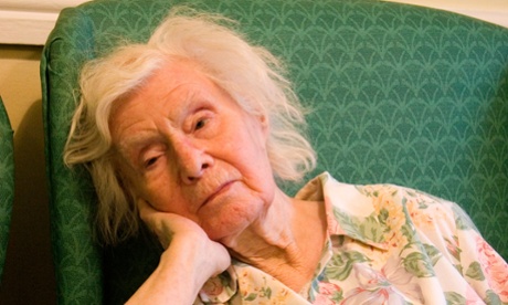 older woman in armchair looking fed up