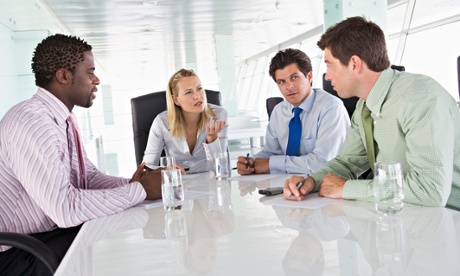Four businesspeople in a boardroom talking