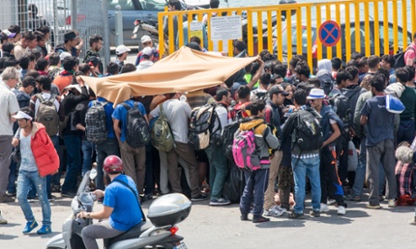 Hundreds of refugees queue outside the gate of the port in Mytilene on Lesbos.