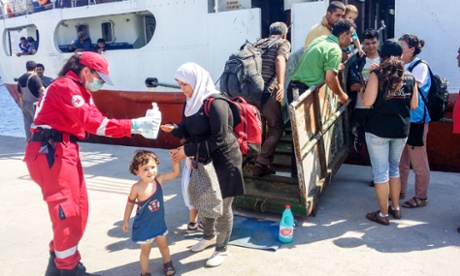 Red Cross volunteers help refugees at the port of Sitia, Crete.