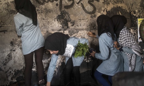 Schoolgirls leave messages of condolence in the burned out home of the Dawabshe family