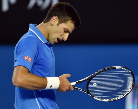 Novak Djokovic looks at his injured thumb.