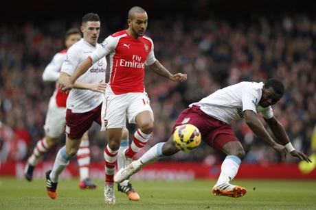Aston Villa's  Jores Okore tries to block an early shot from Theo Walcott.