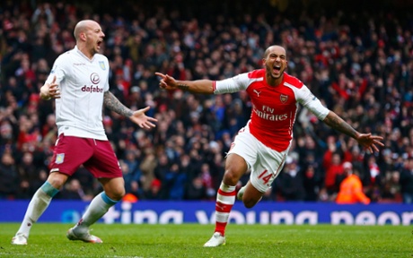 Theo Walcott celebrates his goal as Villa's Alan Hutton screams at his defence.
