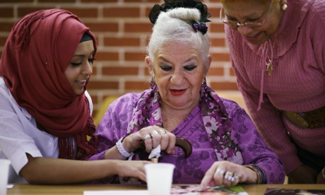 Young woman helps an older one to understand an image