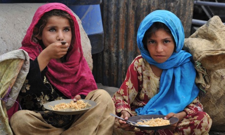 Afghan children eat a meal of rice in Jalalabad