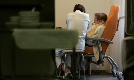 A care worker helps a patient to eat