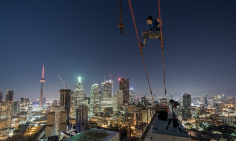 A shot of rooftopping photographer Tom Ryaboi above the streets Toronto. Ryaboi was arrested earlier this month.