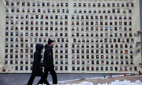 People pass a wall covered with portraits of Ukrainian soldiers who have died in the conflict in eastern Ukraine, in downtown Kiev.