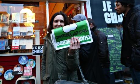A woman holds up a copy of Charlie Hebdo outside a bookshop in London: several UK police forces have