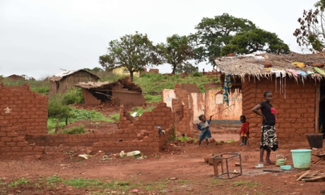 Children stand outside houses damaged by former Seleka fighters in the village of Gaga, near Yaloke.