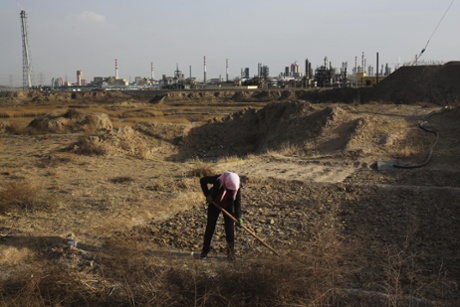 Just a ditch separates the Ningxia Baofeng Energy plant from Li Jiayun (not her real name) who is hoeing her field. Li's family planted 50 to 60 mu of red dates, but after they used the water from the ditch to irrigate the plants, many of them died. Sweet corn also won't grow here. The government moved the villagers to the Hongshiwan Mine Relocation building. They have to travel 2 to 3 km to get to their land. Many of them are willing to build new homes in the old place to be closer to their land