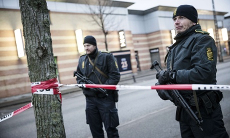 Police survey a street near the site where a man has been shot in Copenhagen.