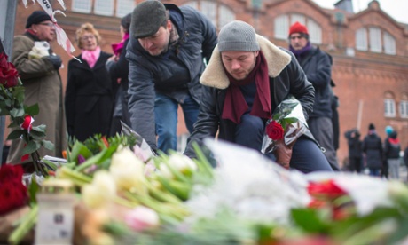 People place flowers close to the scene of the cafe shooting.