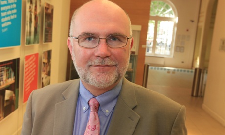 portrait of Mark Porter, bearded and with pink tie