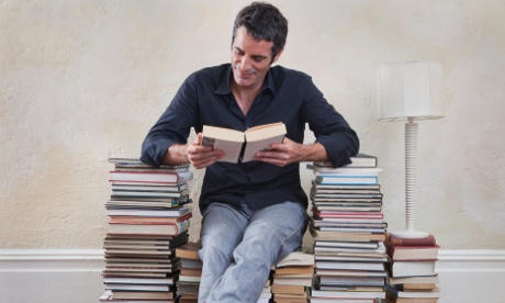 Man sitting on seat made from books