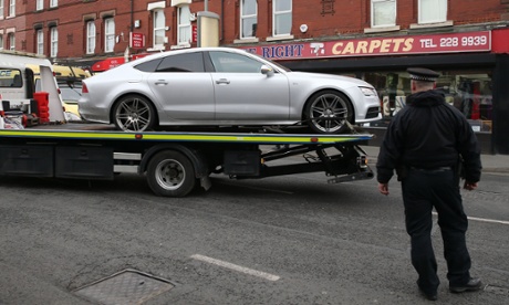 Merseyside police officers take away a car on Prescot Road, Liverpool, after anti-terror police arrested a suspect and searched five addresses in the area.