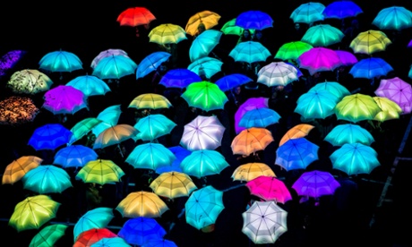 Luminous umbrellas lit beneath high wire artist Jade Kindar-Martin.