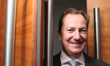 portrait of smiling Philip Monks between set of double doors