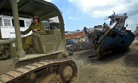 An Australian soldier helps clear tsunami wreckage in February 2005.