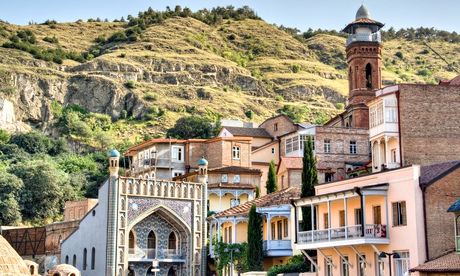 ornate buildings of Tbilisi with hills behind