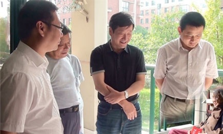 Officials in China's Anhui province have apologised for this doctored photograph, showing a ghostly vice-mayor minus his legs looming over a miniaturised senior citizen.