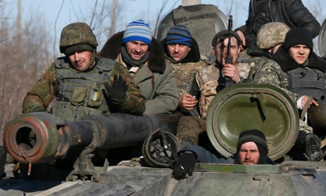 Fatigue in retreat: Ukrainian servicemen sit on top of a tank near Artemivsk, as they withdraw from Debaltseve following a fierce offensive by Russian-backed separatists.