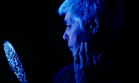 An older woman looks in a mirror