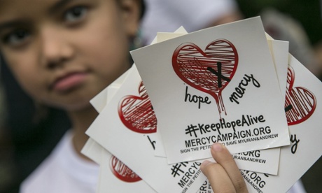 A child holds stickers of a campaign to save two Australian citizens from death sentence