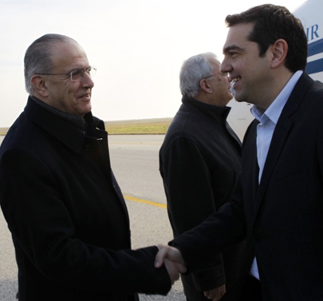 Cypriot Minister of Foreign Affairs Ioannis Kasoulides (L) shaking hands with Greece's new Prime Minister Alexis Tsipras upon the latter's arrival at Larnaca airport in the Cypriot southern port city on February 2, 2015 for his first visit abroad since his election victory.