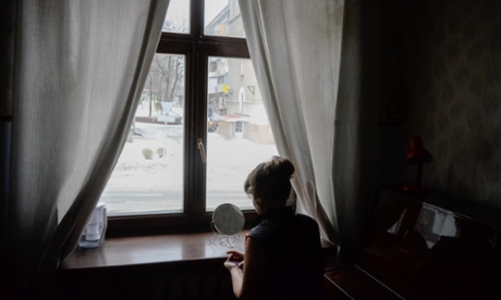 Svetlana Taran-Maleeva, soloist, applies makeup next to a window. The electricity was cut before a performance of Die Fledermaus