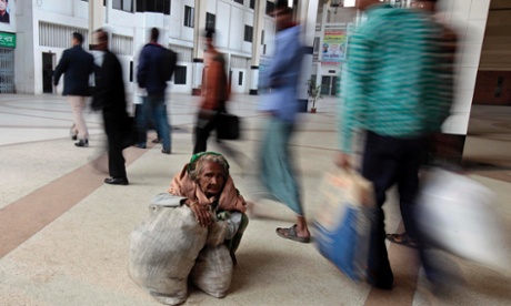 An elderly Bangladeshi woman sits with her luggage at a railway station during a nationwide strike in Dhaka, Bangladesh, January 6, 2013.