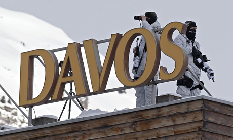 Armed Swiss police officers stand guard on the roof of a hotel the day before the opening of the Wor