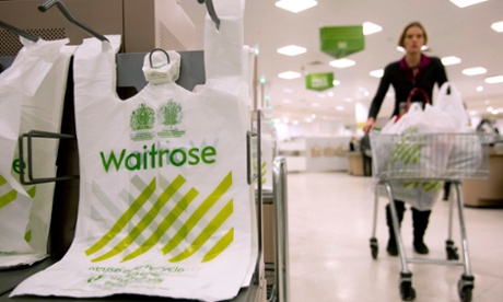 A shopper passes branded bags in the Canary Wharf branch of Waitrose in London