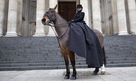 A horsewoman in an outfit designed by Sarah Burton stands outside the cathedral.