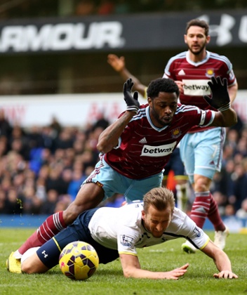 Harry Kane goes down under the challenge from Alexandre Song.