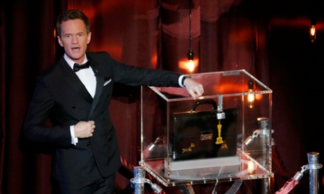 Host Neil Patrick Harris stands next to a sealed briefcase holding his predictions of the Oscar winners.
