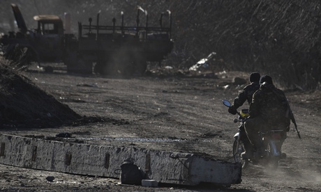 Ukrainian servicemen ride on a motorbike near the village of Luhanske, eastern Ukraine on 24 Februar