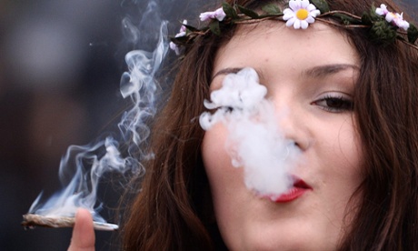 woman wearing daisy chain headgear smokes a cannabis cigarette