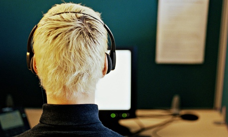 Man in call centre, wearing headset, rear view